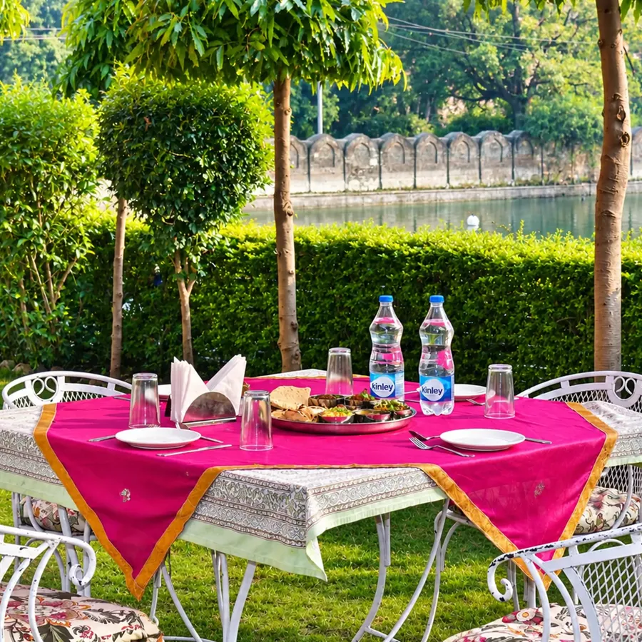 Rajasthani thali laid out on a garden table beside the lake