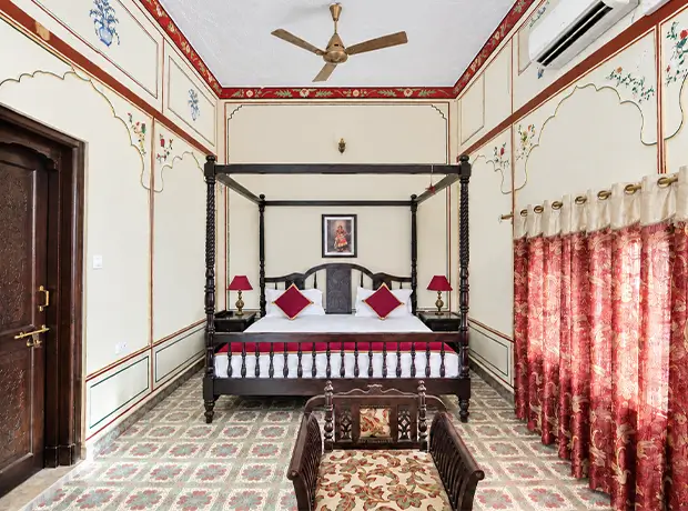 Suite Room at Nawal Sagar Palace with a four-poster canopy bed and painted walls