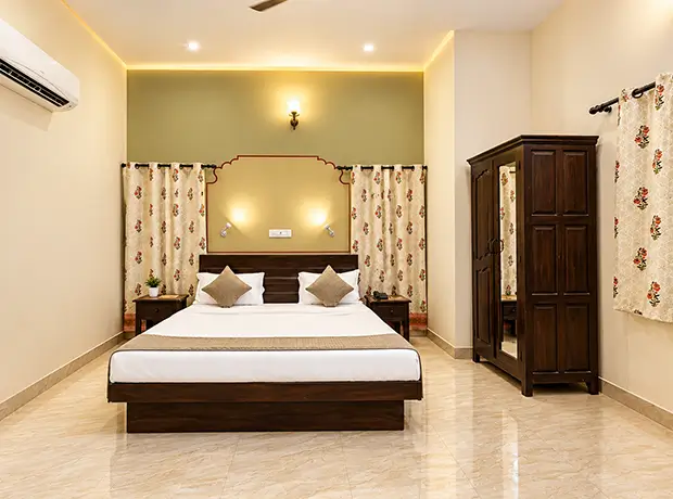 Super Deluxe Room at Nawal Sagar Palace with a king bed and olive accent wall